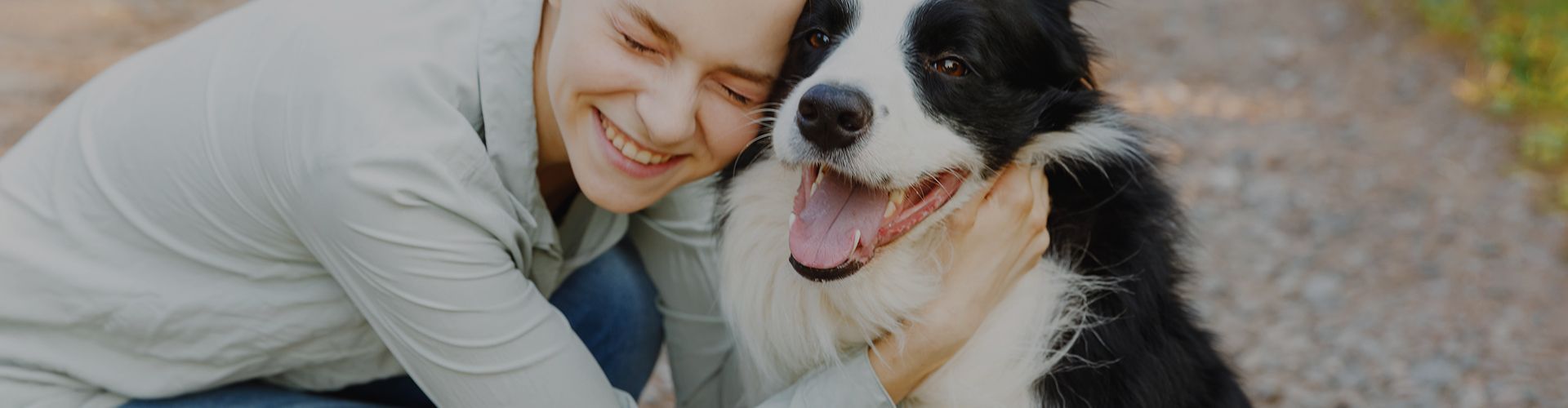 smiling woman hugging happy border collie dog